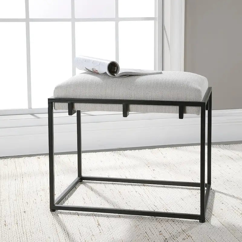 Banco pequeño tapizado blanco con estructura de metal negro